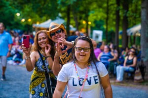 A family enjoys the summer concert, spreading love with heart hands